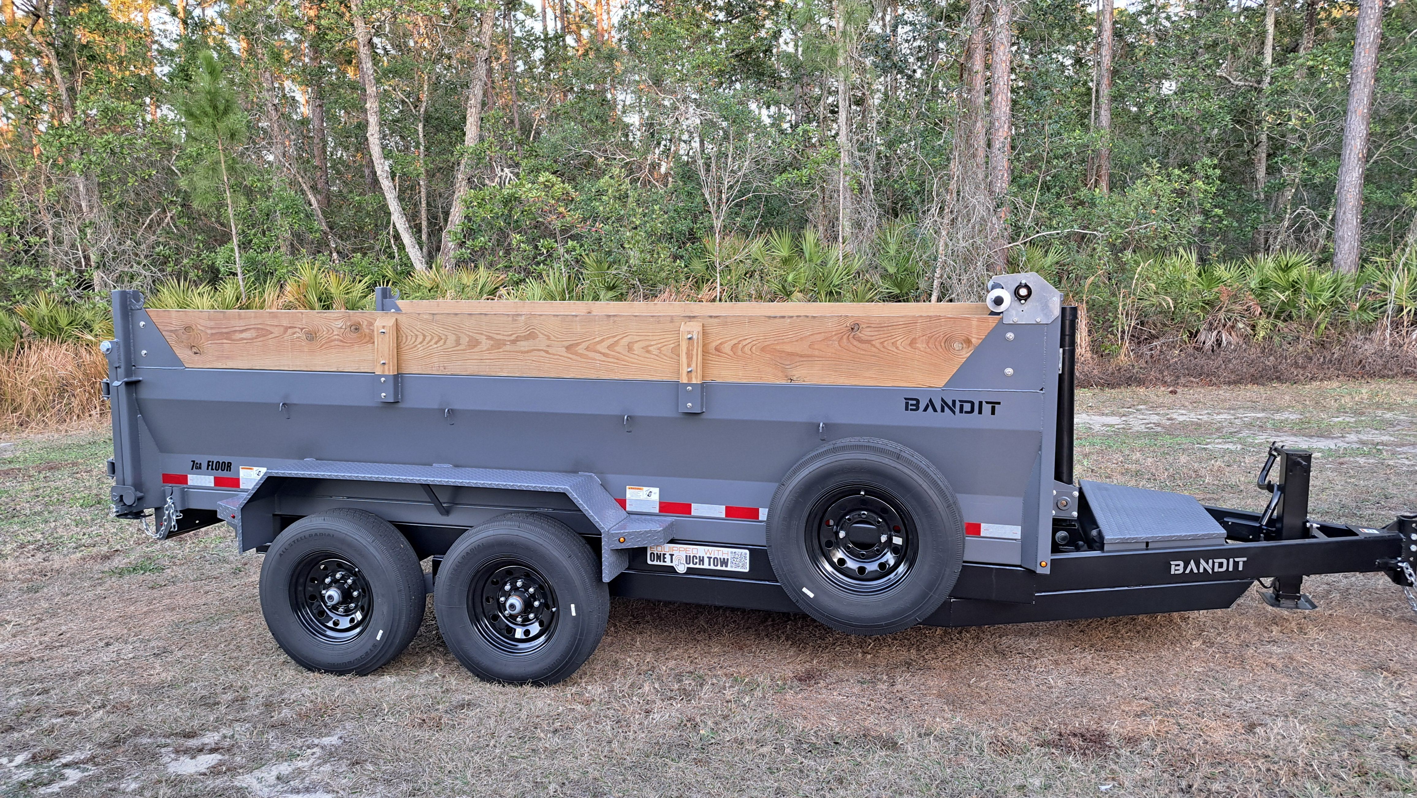 7x14 Bandit dump trailer side view in woods with hydraulic dump