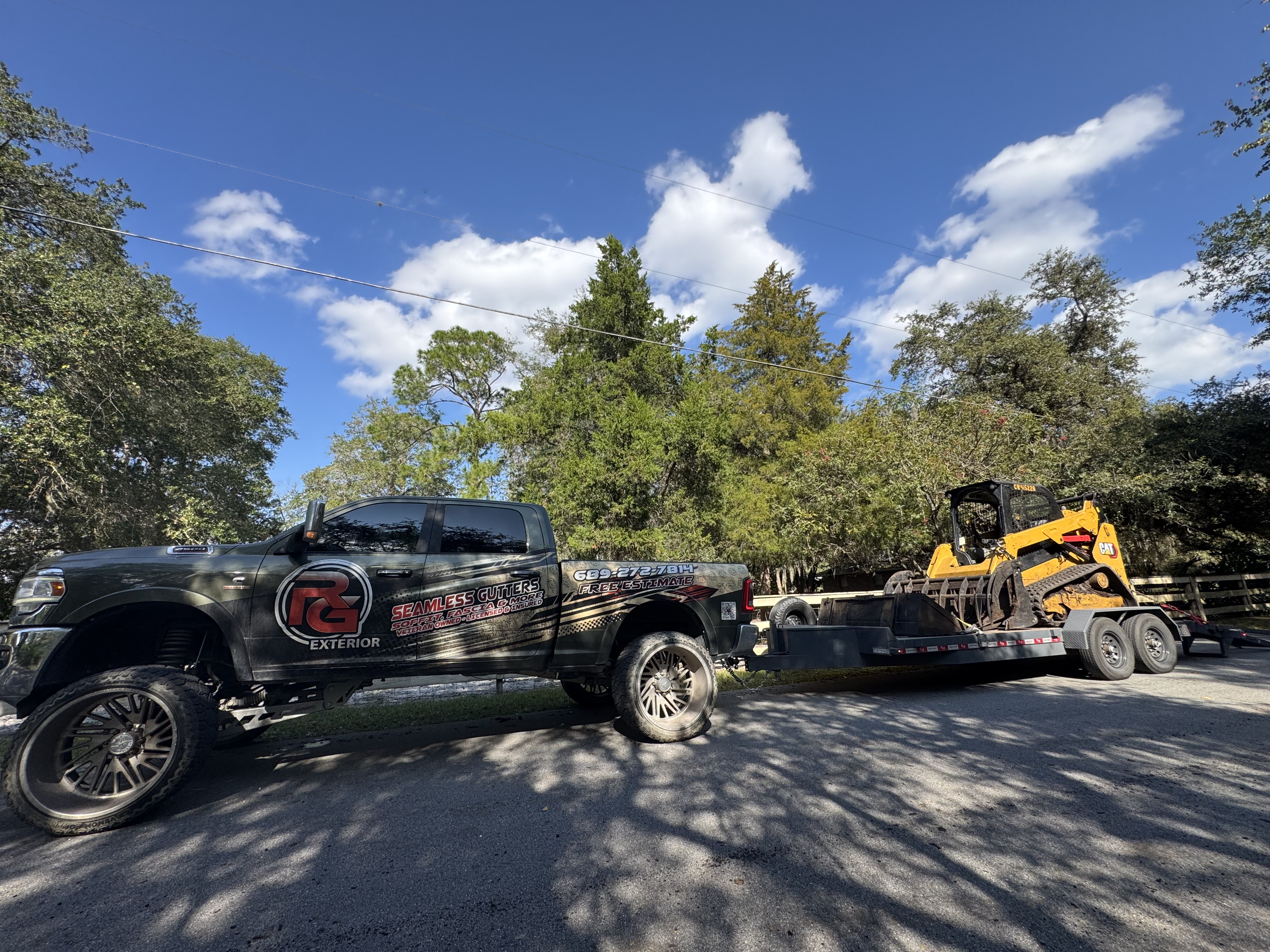 Truck hauling a CAT skid steer on Grace and Grit car hauler trailer